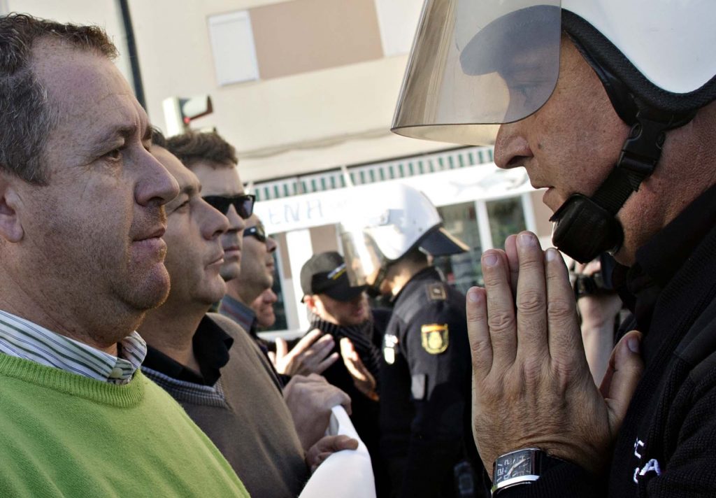 A policemen speaks with a member of the General Union Workers (UGT) during a demonstration against the new budget policies of the goverment  in Cadiz, Spain on Dec. 9, 2010. (Miguel Gomez/La Voz De Cadiz)
