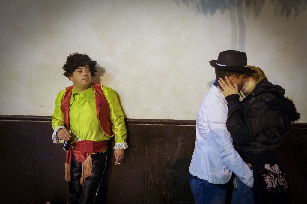 A man looks on a couple's kiss during Cadiz's Carnival Parade in Cadiz, Spain on Feb. 3 in 2008. (AP Photo/Miguel Gomez)