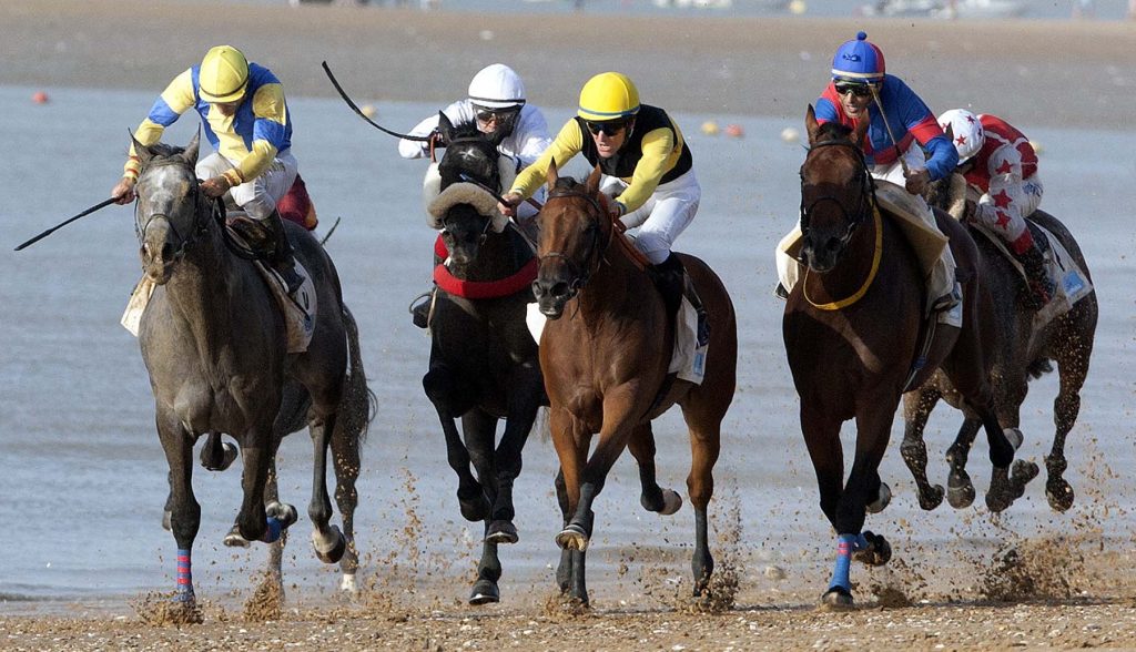 Jockeys race along the beach during the traditional beach race on the Sanlucar de Barrameda's beach in southern Spain, on August 10, 2011. Sanlucar horse racing dates back to 1845 and is some of the oldest in Europe, it currently takes place near the mouth of the Rio Guadalquivir several times during the month of August. (AP Photo/Miguel Gomez)
