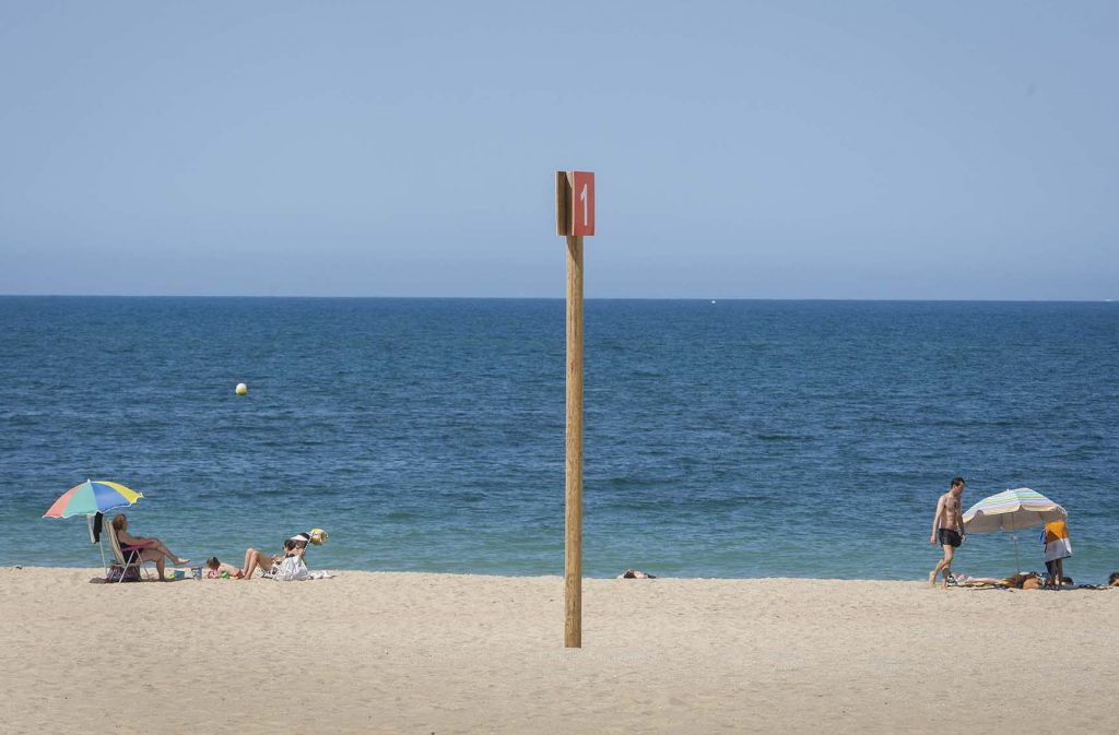 Dos familias guardan la distancia de seguridad en la Playa La Victoria en Cádiz, España, el 14 de julio de 2020. Algunos vuelven a las playas con cierta cautela mientras Sanidad alerta del peligro de relajación ante el virus en estas vacaciones.